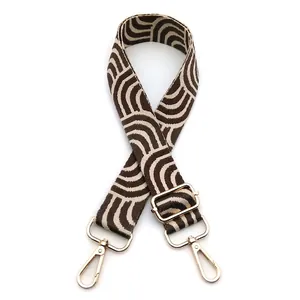 Close-up of brown and beige geometric woven bag strap with gold metal hooks