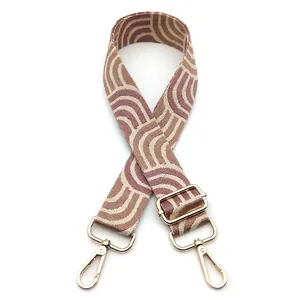 Detail of purple and beige geometric wave strap with golden metal lobster clasps