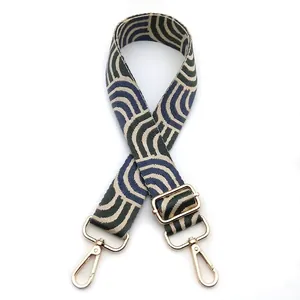 Detail of adjustable wide fabric bag strap with dark green wavy geometric patterns