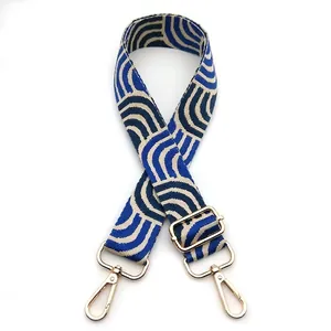 Detail of adjustable blue and beige geometric pattern strap with gold metal hooks