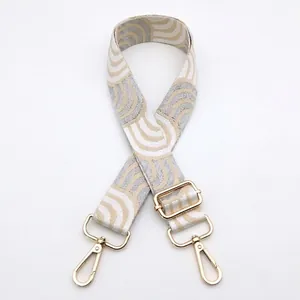 Detail of adjustable geometric wavy strap with gold metal buckles and lobster clasps