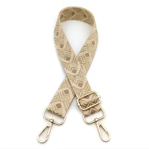 Detail view of woven bohemian bag strap with geometric patterns and golden metal hooks
