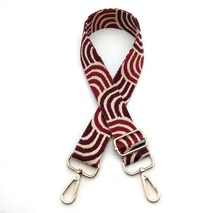 Detail of adjustable woven bag strap No.15 with burgundy geometric patterns and gold clips