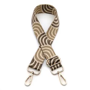 Detail of adjustable woven bag strap with golden metal hooks and wave pattern