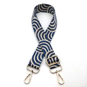 Close-up of geometric wave pattern webbing strap with golden metal swivel lobster clasps