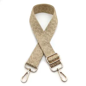 Detail view of 3.8cm wide khaki zigzag woven shoulder strap with gold metal lobster clasps