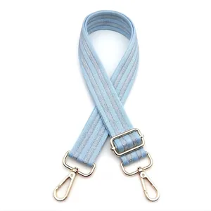 Detail of adjustable light blue zigzag woven strap with premium gold metal hardware
