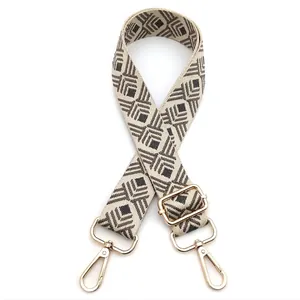 Close-up of geometric diamond pattern on wide canvas guitar strap with gold hardware hooks