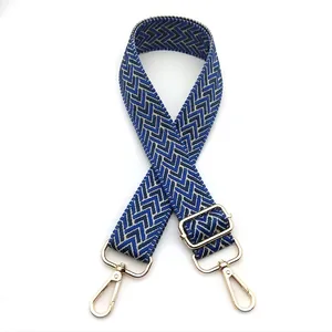 Detail view of 3.8cm adjustable bag strap with blue chevron weaving and gold lobster clasps