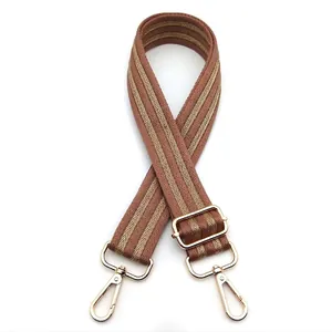 Close-up of brown and gold wave patterned adjustable shoulder strap with metal buckles