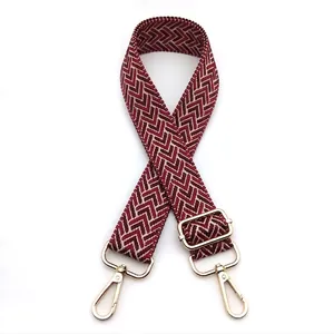 Close-up of 3.8cm wide adjustable bag strap with red chevron weave and gold metal hardware