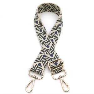 Detail of geometric jacquard bag strap with blue diamond patterns and gold hooks