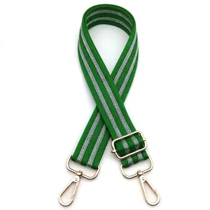 Detail of adjustable green and white striped canvas strap with gold metal lobster clasps