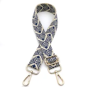 Detailed view of adjustable wide bag strap with navy and beige geometric diamond pattern