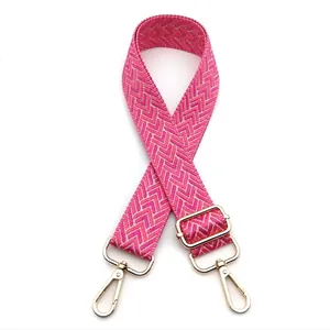 Detail of a 3.8cm wide adjustable woven shoulder strap in pink with gold chevron patterns