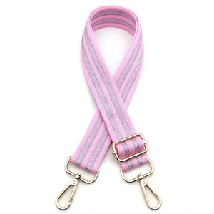 Detail of pink and silver striped replacement bag strap with golden metal lobster clasps