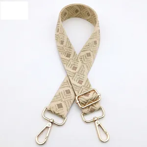 Detail view of adjustable beige and brown diamond pattern woven strap with gold hardware