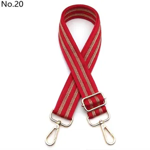 Detail of red woven bag strap No. 20 with gold chevron pattern and metal lobster clasps