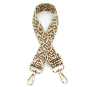 Detail of adjustable geometric diamond pattern bag strap with gold metal lobster clasps