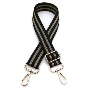 Close-up of black and gold woven strap with adjustable golden metal buckle and lobster clips