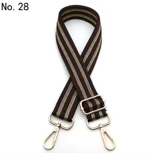Detail of adjustable brown knit bag strap with gold metal lobster clasps and V-pattern