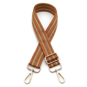 Adjustable woven shoulder strap in tan with yellow chevron pattern and gold metal hooks