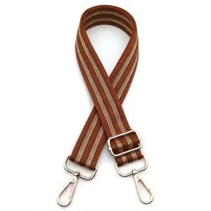 Close-up of adjustable striped brown and gold shoulder strap with gold metal swivel hooks