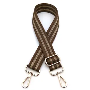 Detail of adjustable chevron patterned bag strap with golden metal swivel hooks