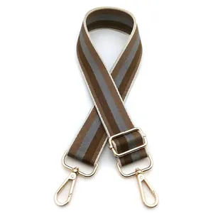 Close-up of adjustable striped handbag strap with golden metal lobster clasps