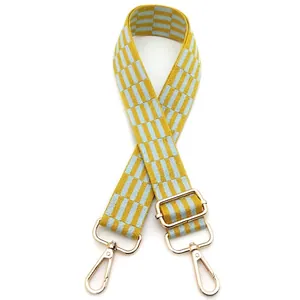 Close-up of adjustable yellow and blue striped bag strap with gold metal hooks