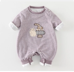 Detail of baby romper featuring cartoon bear patch embroidery and soft ribbed cuffs