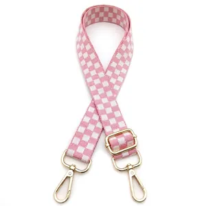 Close-up of pink and white checkered bag strap with adjustable gold lobster clasps