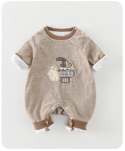 Detail view of bear and mushroom embroidery on soft long sleeve baby romper