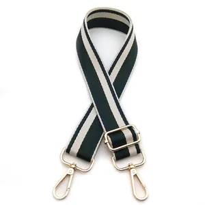 Detail of adjustable striped bag strap with gold metal hooks in green and navy
