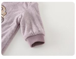 Detail of lavender baby romper featuring ribbed elastic cuffs and a cute cartoon appliqué