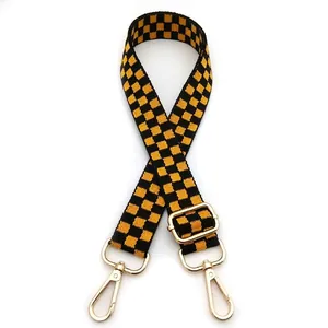 Detail of yellow and black checkered strap with adjustable gold metal lobster clasps