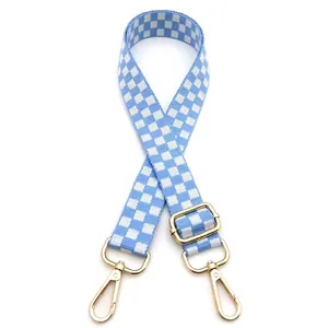 Detailed close-up of blue and white checkered bag strap with golden metal buckle