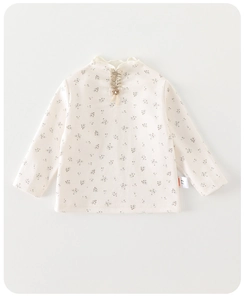 Close-up of baby floral top with lace flower detail and elastic mock neck collar
