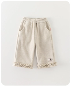 Detailed view of beige toddler casual pants featuring ruffle hems and elastic waistband