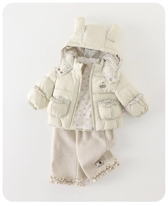 Flat lay of cream toddler winter set featuring a hooded jacket and ruffled pants
