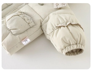Detail of baby winter jacket showing floral ruffles, embroidery and size label 73