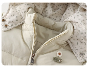 Detailed close-up of quilted winter vest with floral lining and decorative knit flowers