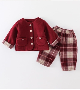 Detail of red buttoned jacket and plaid trousers for baby girls winter festive outfit