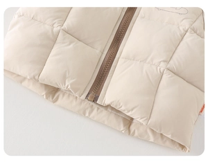 Detail view of quilted toddler vest showing premium zipper and soft cream fabric texture