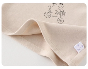 Close-up of soft cream fleece fabric with minimalist cartoon print and quality garment tag