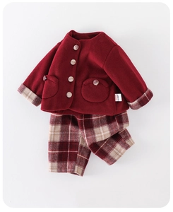 Close-up of deep red wool-like jacket and brown plaid pants for toddler girls