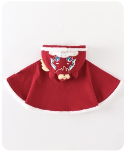 Dettaglio della mantella rossa tradizionale per bambini con ricamo leone e bordo in pelliccia
