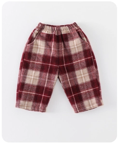 Detailed view of red and beige checkered woolen trousers with an elastic waistband for kids