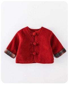 Detail of red festive baby coat featuring traditional Chinese knots and plaid cuffs