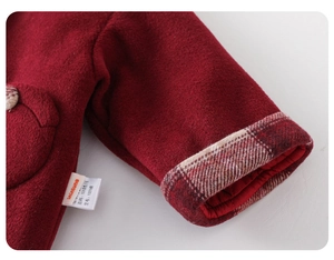 Close-up of baby winter wool set showing red fabric texture and plaid lining detail